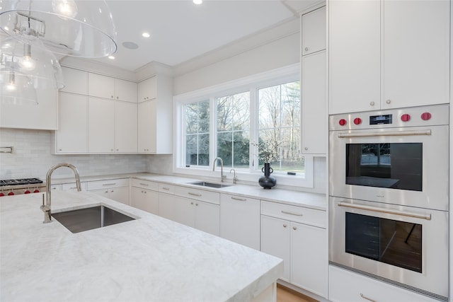 kitchen with white cabinetry, double oven, and sink