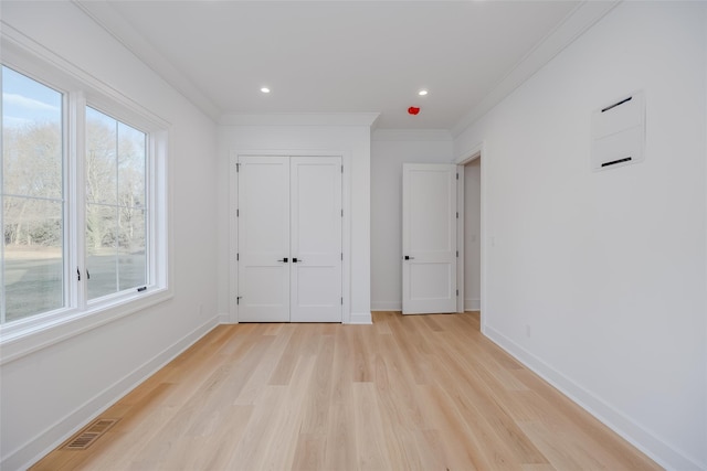 unfurnished bedroom with light wood-type flooring and ornamental molding