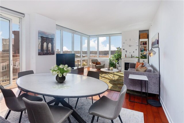 640 W 237th St Unit 12B, Bronx, NY 10463 - dining space with wood-type flooring, a wall of windows, and a healthy amount of sunlight