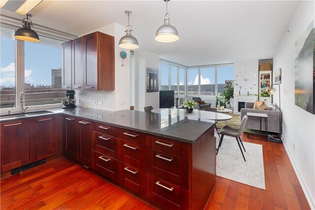 640 W 237th St Unit 12B, Bronx, NY 10463 - kitchen with sink, dark hardwood / wood-style floors, dark stone counters, decorative light fixtures, and decorative backsplash