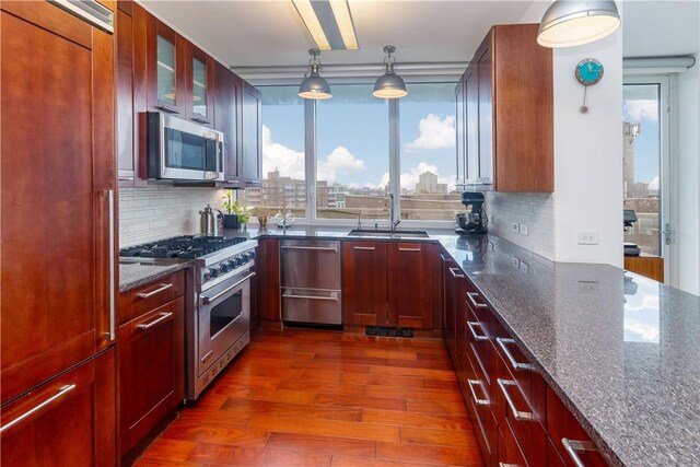 640 W 237th St Unit 12B, Bronx, NY 10463 - kitchen featuring dark hardwood / wood-style flooring, dark stone counters, stainless steel appliances, sink, and hanging light fixtures