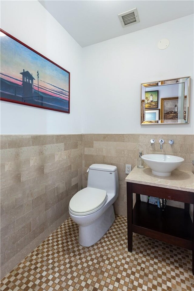 640 W 237th St Unit 12B, Bronx, NY 10463 - bathroom with tile patterned floors, toilet, sink, and tile walls