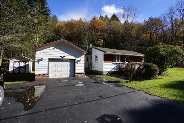 ranch-style house with covered porch, a storage unit, a garage, and a front yard