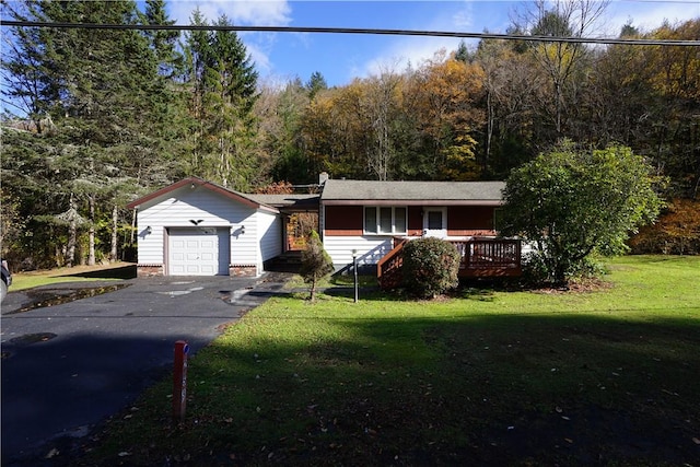 view of front of house with a wooden deck, a front lawn, and a garage