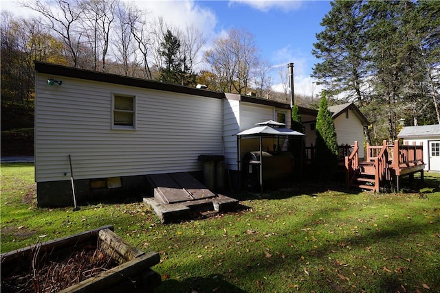 back of property featuring a gazebo, a yard, and a deck