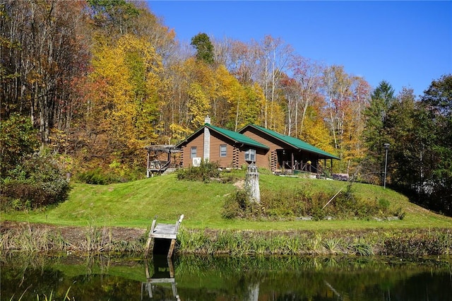 view of property's community featuring a boat dock, a yard, and a water view