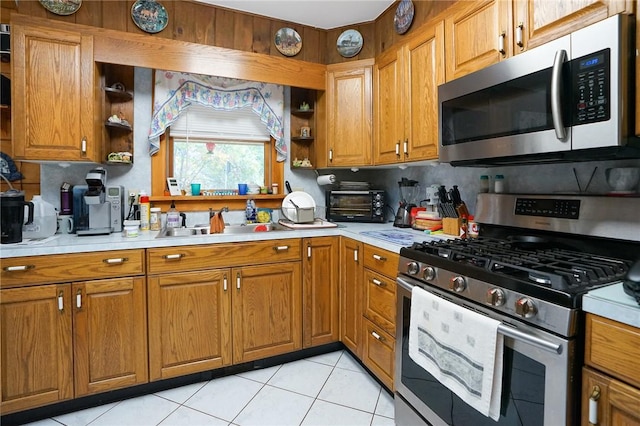 kitchen with light tile patterned floors, stainless steel appliances, tasteful backsplash, and sink