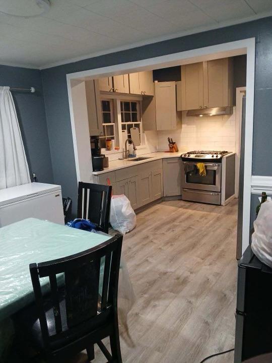 kitchen with stainless steel gas stove, sink, white refrigerator, backsplash, and light hardwood / wood-style floors