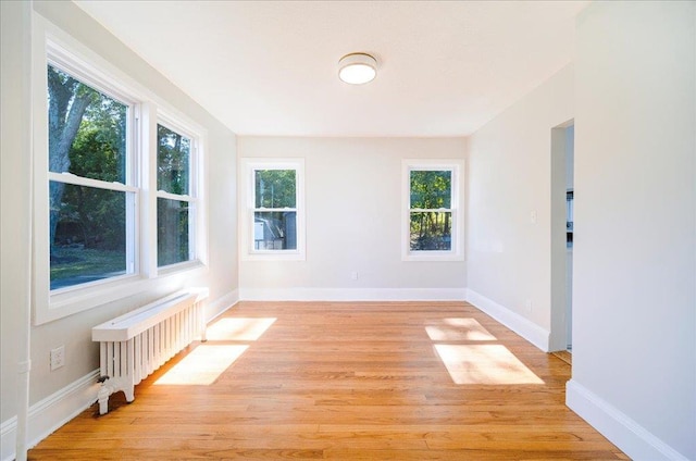 spare room featuring light wood-type flooring and radiator heating unit