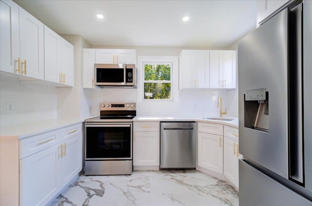 kitchen with appliances with stainless steel finishes, backsplash, white cabinetry, and sink