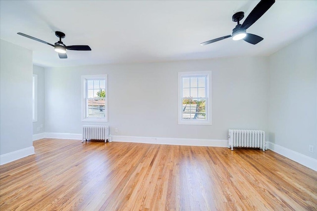 spare room with plenty of natural light, light hardwood / wood-style floors, and radiator