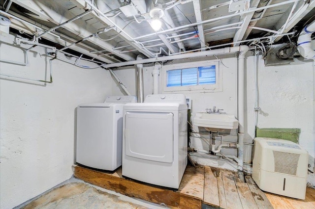 laundry area with separate washer and dryer and sink