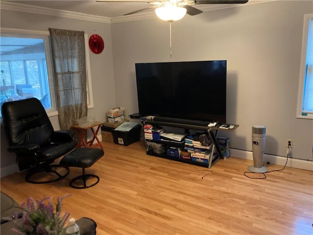 living room with ceiling fan, ornamental molding, and light hardwood / wood-style flooring