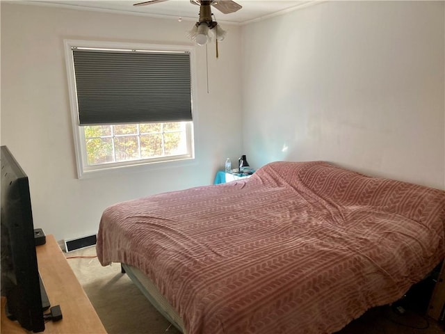 carpeted bedroom featuring ceiling fan and crown molding