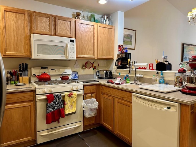 kitchen with kitchen peninsula, white appliances, and sink