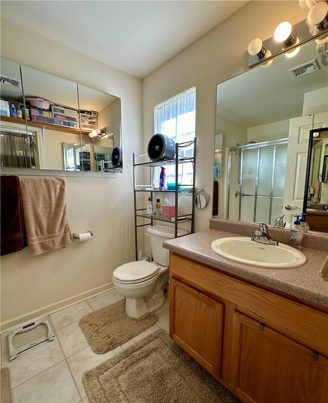 bathroom with toilet, vanity, tile patterned floors, and a shower with door