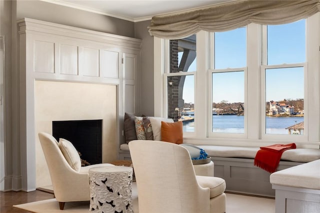 living area with a water view, ornamental molding, and wood-type flooring