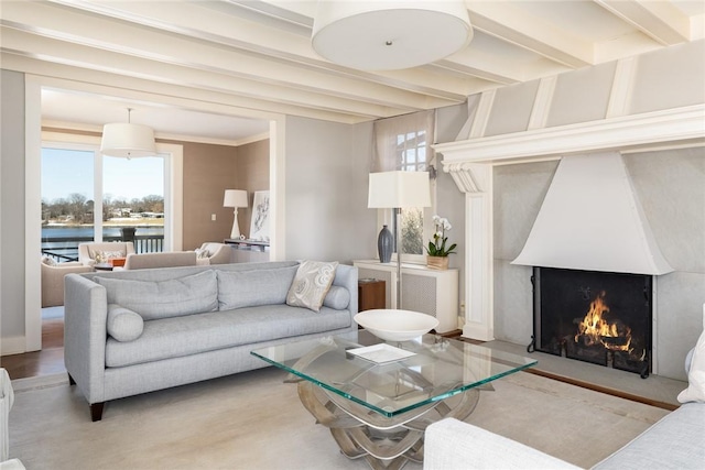 living room featuring crown molding, a fireplace, and beamed ceiling