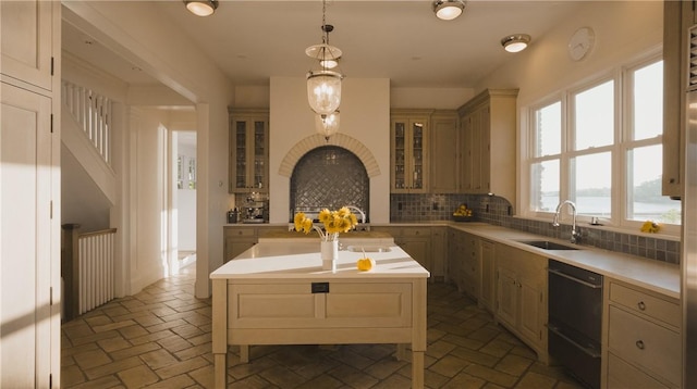 kitchen with tasteful backsplash, a center island, sink, decorative light fixtures, and black dishwasher