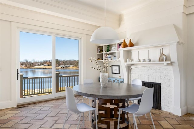 dining room with a water view and a fireplace