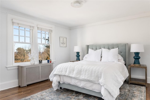 bedroom featuring radiator, dark hardwood / wood-style floors, and ornamental molding