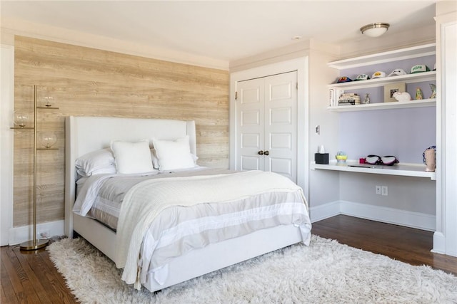 bedroom featuring dark wood-type flooring and wooden walls