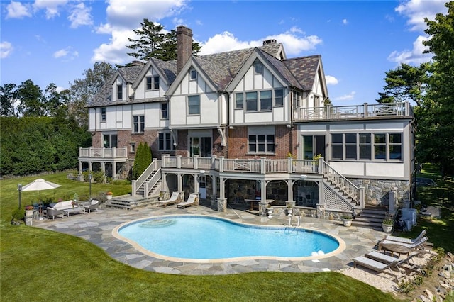 back of house featuring a yard, a patio, and a balcony