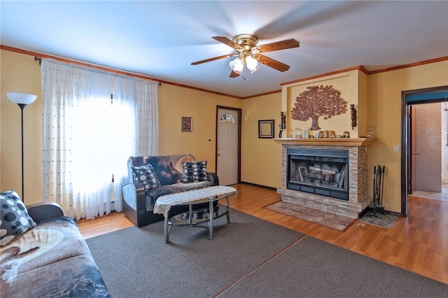 living room featuring light wood-type flooring, ceiling fan, and ornamental molding