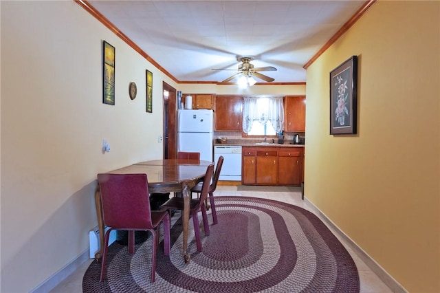 tiled dining area with ceiling fan and crown molding