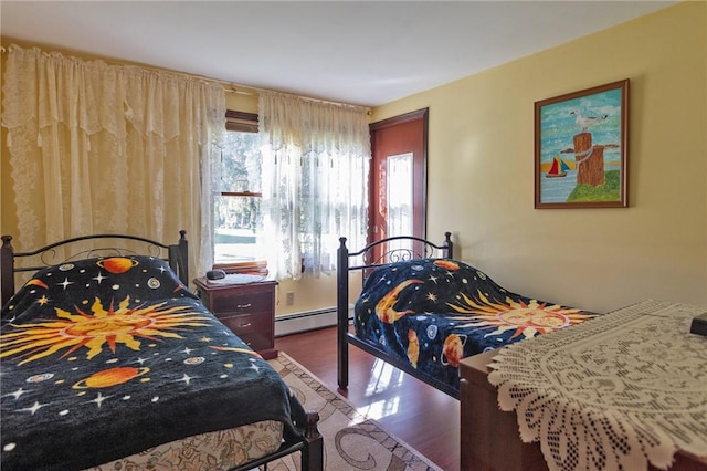 bedroom featuring dark wood-type flooring and a baseboard heating unit