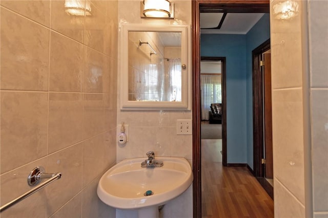 bathroom featuring hardwood / wood-style flooring, tile walls, and sink