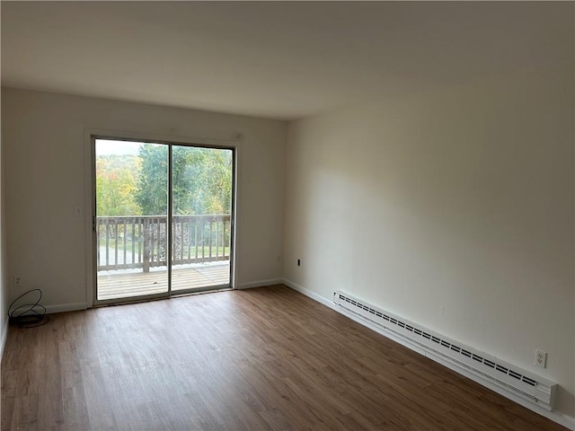 spare room with a baseboard radiator and wood-type flooring