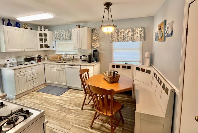 kitchen featuring hanging light fixtures, sink, white appliances, and white cabinetry