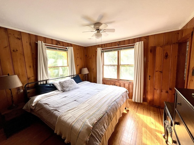 bedroom with ceiling fan, crown molding, hardwood / wood-style flooring, and multiple windows