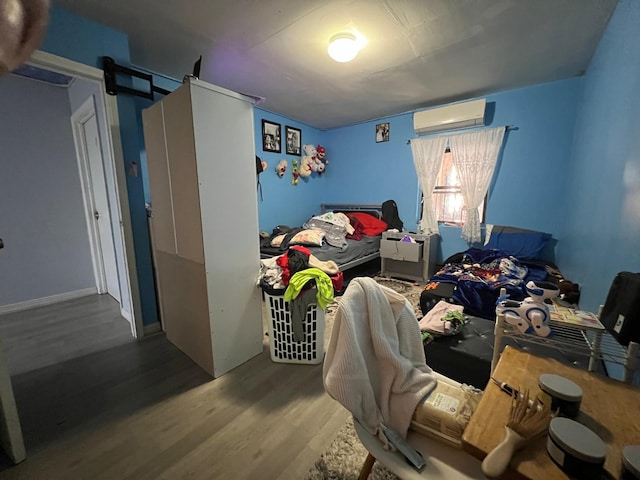 bedroom with hardwood / wood-style flooring and a wall mounted AC