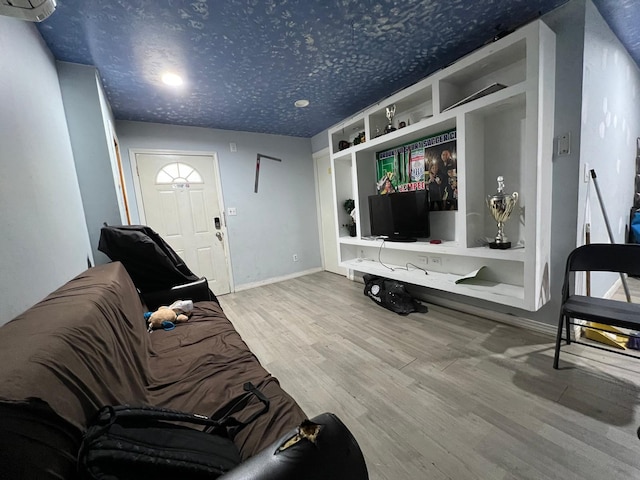 living room with built in shelves and hardwood / wood-style floors