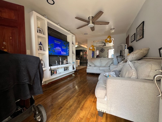 living room featuring built in shelves, ceiling fan, and hardwood / wood-style floors