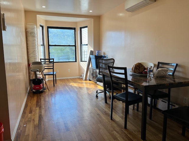 dining area with a wall unit AC and hardwood / wood-style flooring