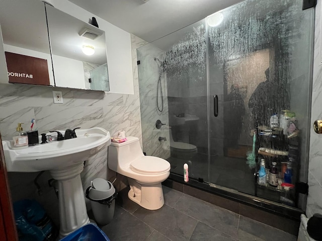 bathroom with an enclosed shower, tile patterned floors, toilet, and tile walls