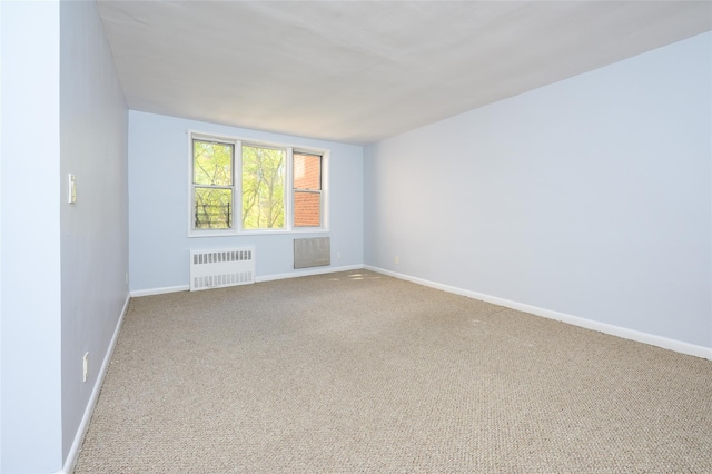 spare room featuring radiator heating unit and carpet floors