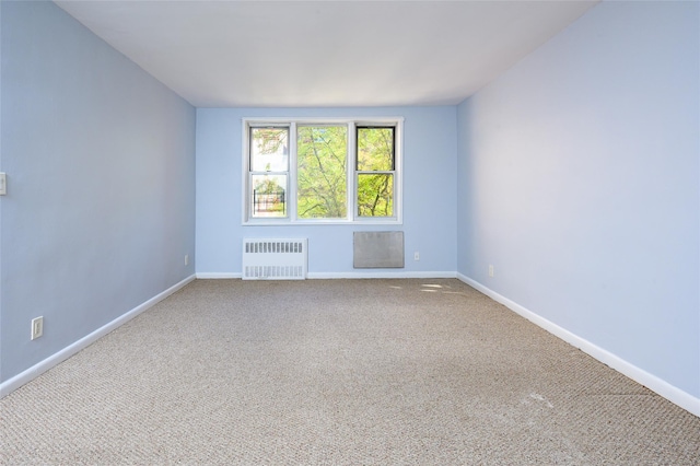 carpeted spare room featuring radiator