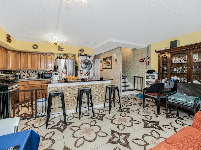 kitchen featuring a chandelier, a kitchen breakfast bar, stainless steel appliances, and light tile patterned floors