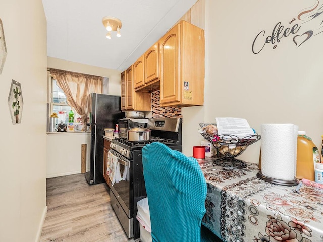 kitchen with light wood-type flooring, backsplash, and appliances with stainless steel finishes