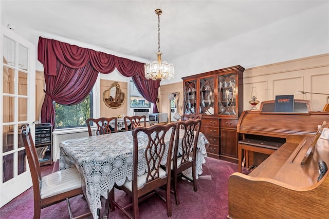 carpeted dining room featuring a chandelier