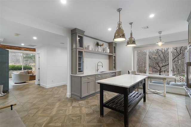 kitchen with pendant lighting, light parquet flooring, gray cabinets, and sink