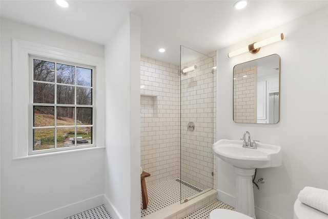 bathroom with toilet, tile patterned flooring, and tiled shower