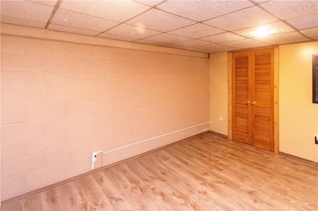 basement featuring a paneled ceiling and wood-type flooring