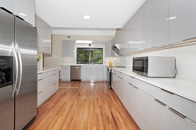7 High Point Cir, Chappaqua, NY 10514 - kitchen with stainless steel appliances, modern cabinets, light wood-style flooring, light countertops, and recessed lighting