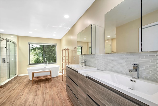 7 High Point Cir, Chappaqua, NY 10514 - bathroom featuring double vanity, a stall shower, a freestanding tub, wood finished floors, and tasteful backsplash