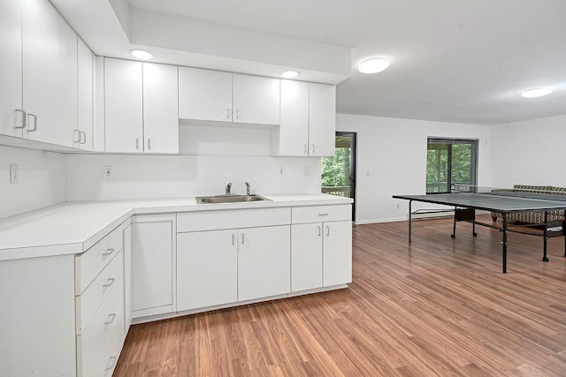 7 High Point Cir, Chappaqua, NY 10514 - kitchen featuring a sink, light countertops, light wood-style flooring, white cabinetry, and baseboards